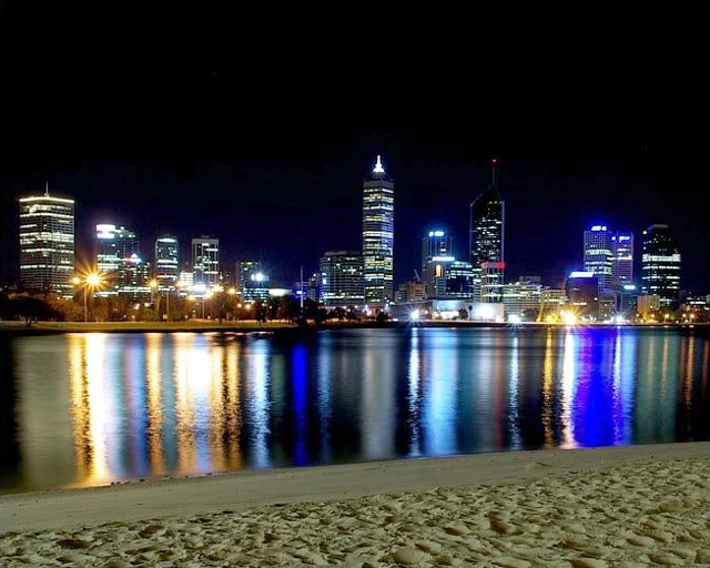 Perth skyline at night reflecting in water - property investment opportunities in Western Australia